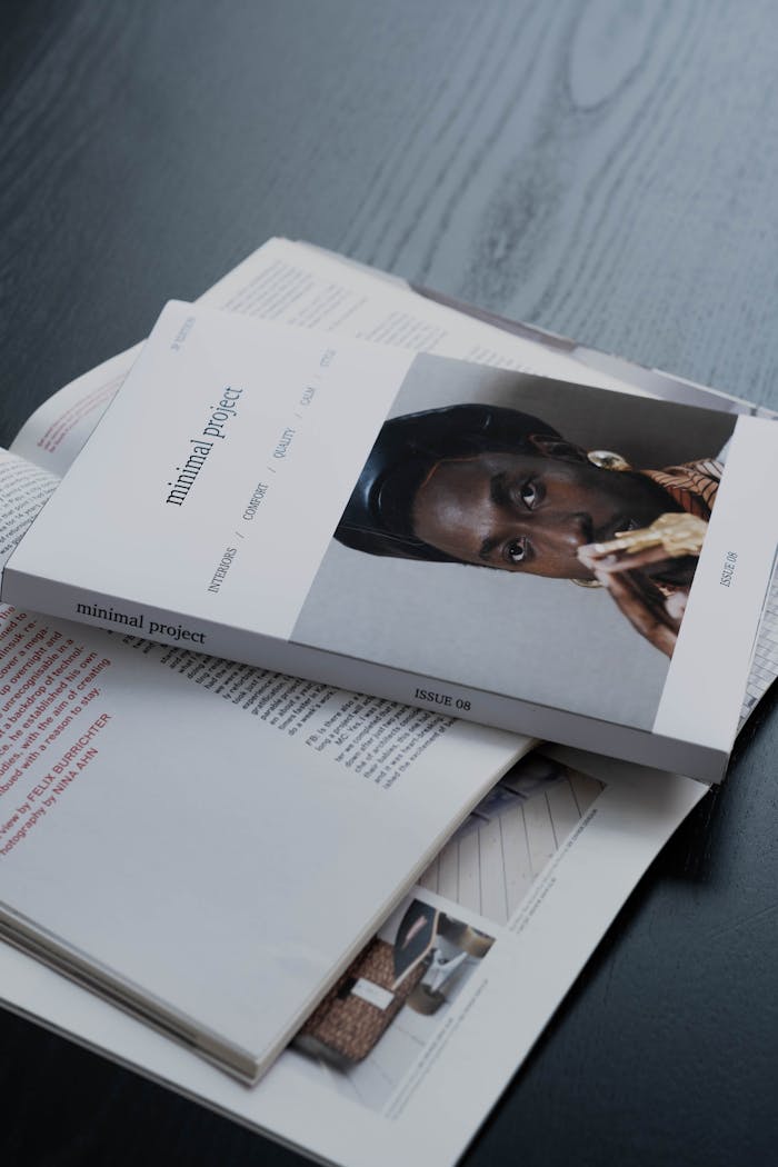 Elegant close-up of minimalist magazines on a dark wooden table, showcasing modern design.