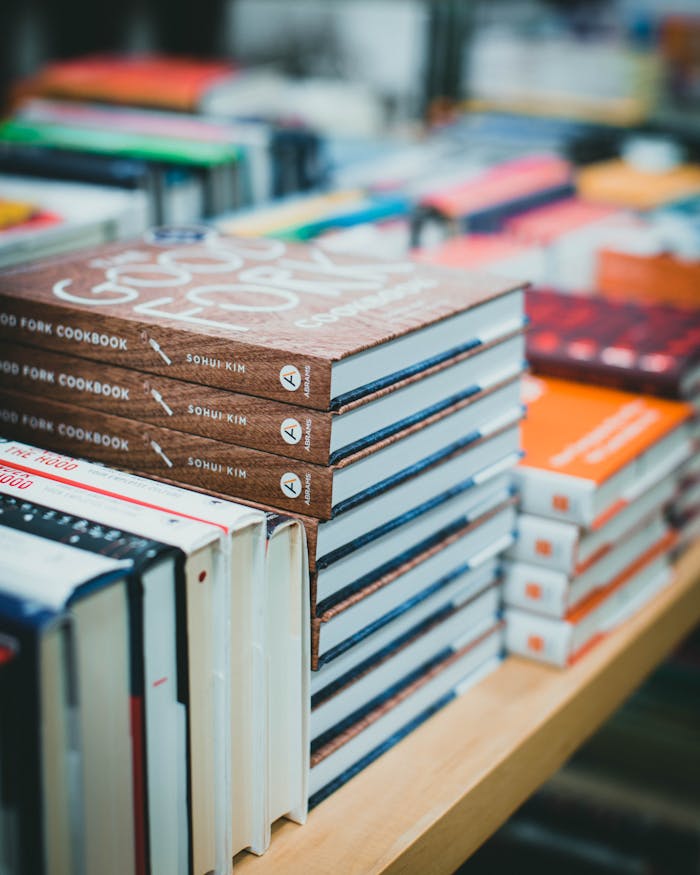 Close-up of various books stacked on a table in a bookstore, showcasing covers.